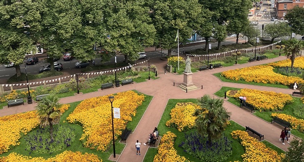 The image shows Queens Gardens, photographed from above, with hundreds of yellow blooms.