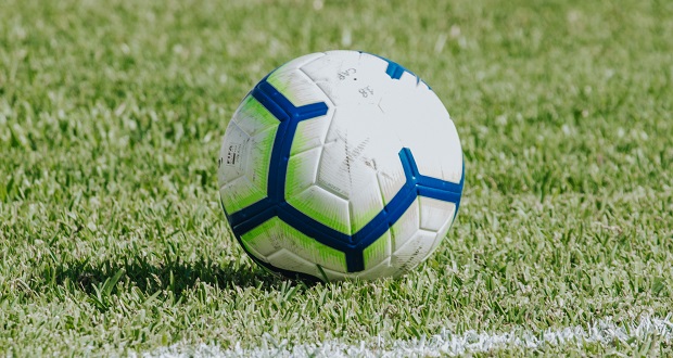 The image shows a football next to a white line.